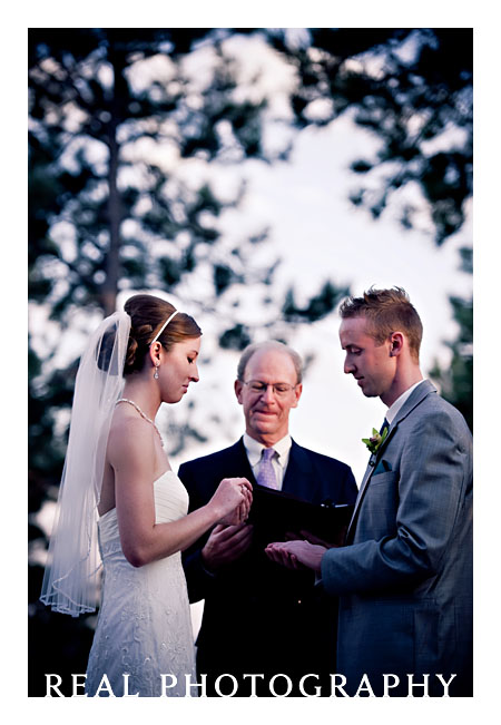 bride and groom outside with trees ring exchange
