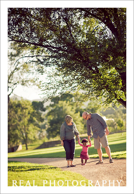 family walking with toddler outside in sunset light evening